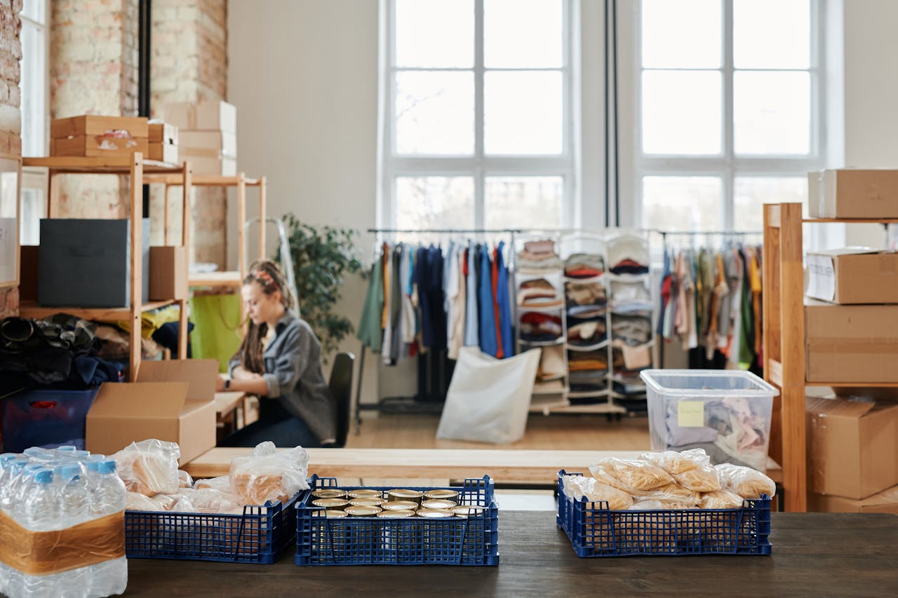 Warehouse with packaged food and clothing storage, worker organizing stock indoors.
